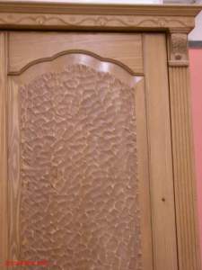 Mit Holzschnitzerei und geschnitzten Leisten verzierte Türfront.